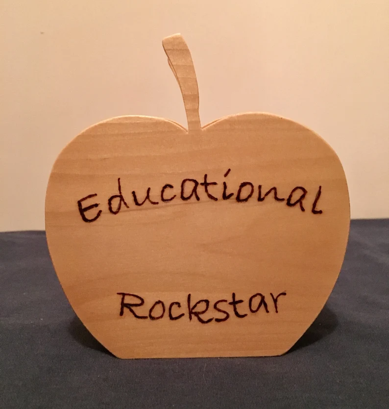 Wooden pencil holder that says "Educational Rockstar"