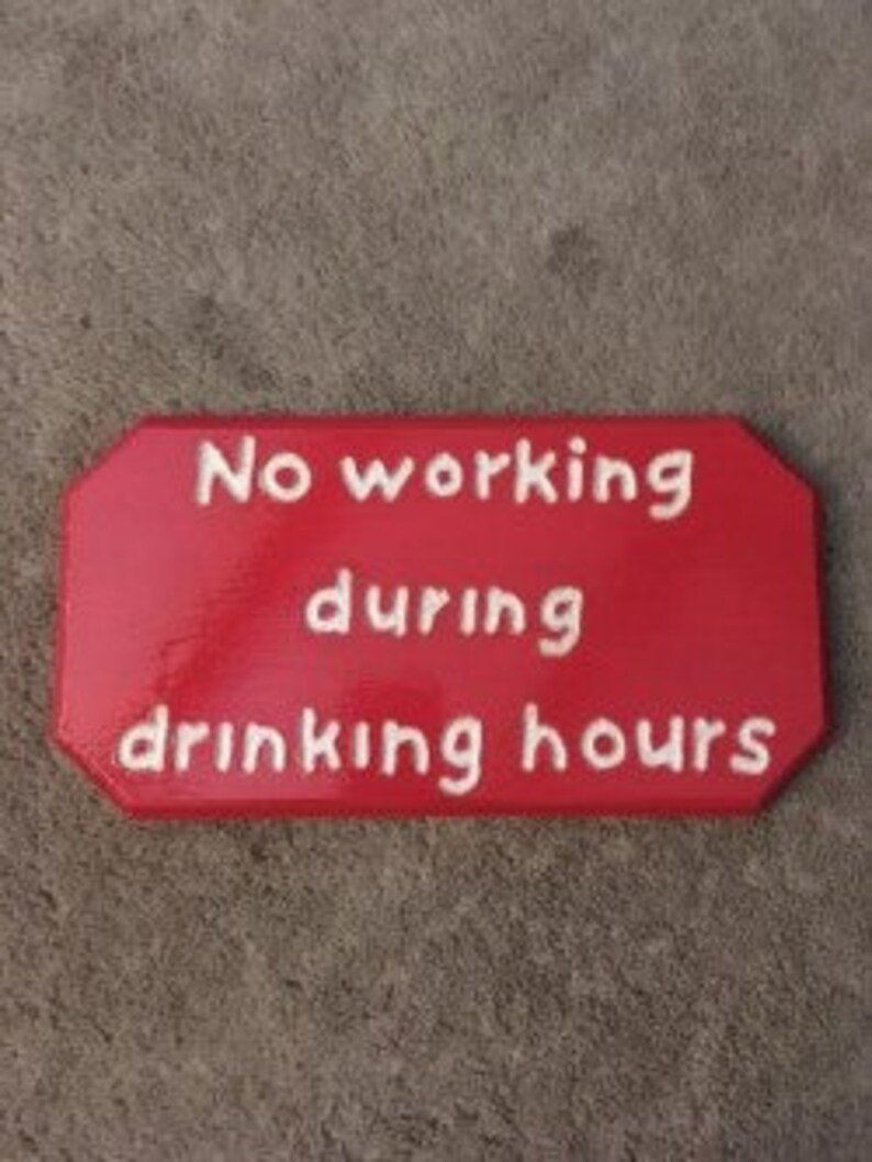 Red wooden plaque that says "no working during drinking hours"