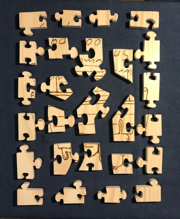 Separated wooden puzzle pieces of a wood burned Snoopy on his doghouse