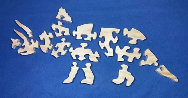 Separated pieces of a wooden Triceratops puzzle